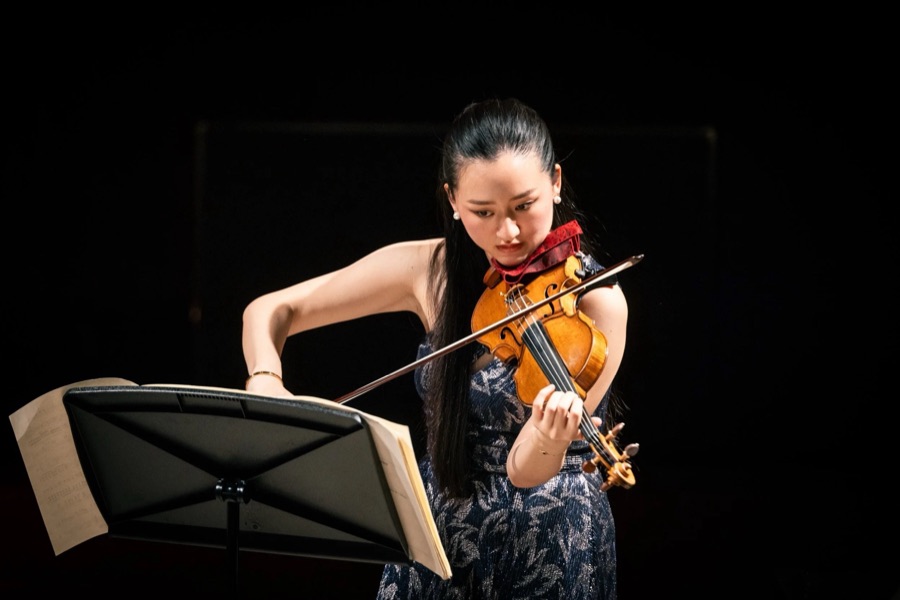 Karen Su in performance against a dark stage background
